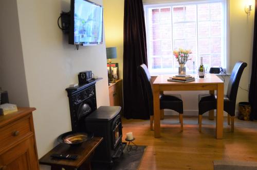 a living room with a dining room table and a television at 19 Upper Linney in Ludlow