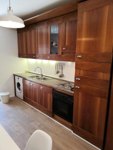 a kitchen with wooden cabinets and a sink at Casa Mari in Principina Terra