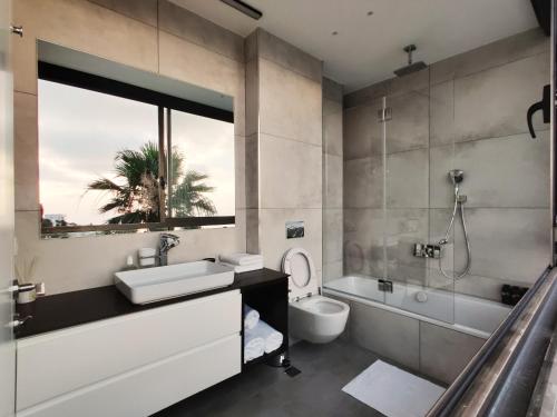 a bathroom with a sink and a tub and a toilet at Luxury Suites by Notaly Ariel in Haifa