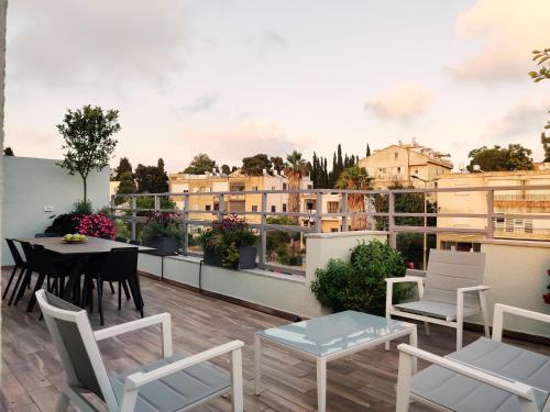 een balkon met een tafel en stoelen en uitzicht op de gebouwen bij Luxury Suites by Notaly Ariel in Haifa