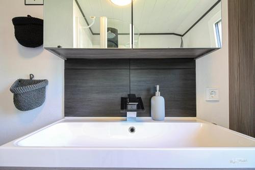 Ferienwohnung Traumblick في Wolfshagen: حوض استحمام أبيض في حمام مع مرآة