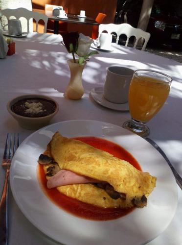 a white plate with an omelet on a table at Hotel Holly in Mérida