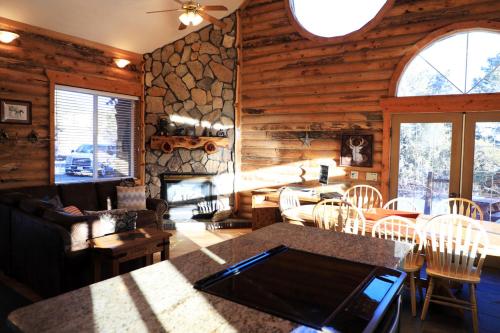 a living room with wooden walls and a stone fireplace at Zion Ponderosa Ranch Resort in Springdale