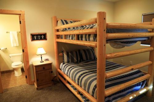 a bedroom with two bunk beds and a bathroom at Zion Ponderosa Ranch Resort in Springdale