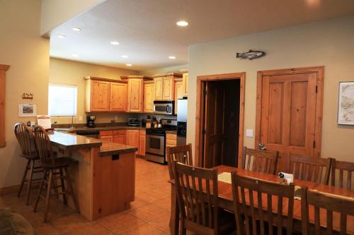 a kitchen with wooden cabinets and a table and chairs at Zion Ponderosa Ranch Resort in Springdale