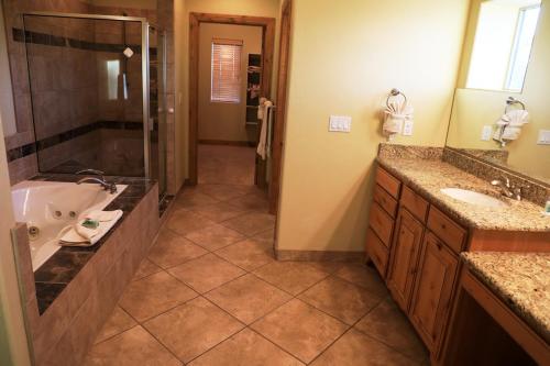 a bathroom with a tub and a sink and a shower at Zion Ponderosa Ranch Resort in Springdale
