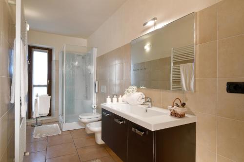 a bathroom with a sink and a toilet and a mirror at Vista Sulle Langhe in Carrù