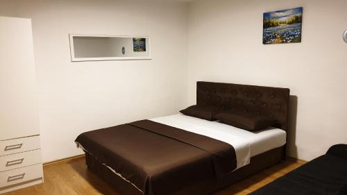 a bedroom with a bed with a brown headboard at Accommodation Vesa in Mostar