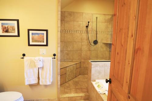 a bathroom with a shower and a toilet at Zion Ponderosa Ranch Resort in Springdale
