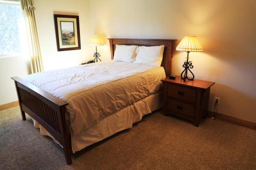 a bedroom with a bed and two lamps on a night stand at Zion Ponderosa Ranch Resort in Springdale