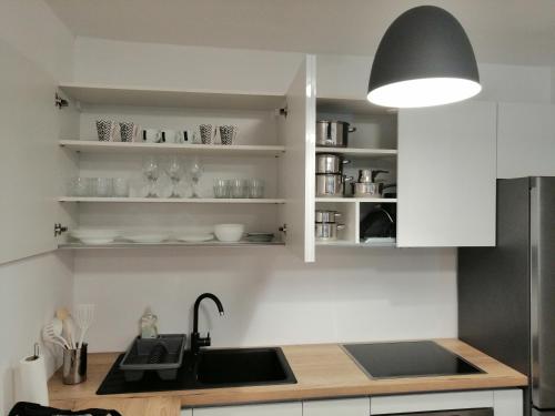 a kitchen with white cabinets and a sink at Portus in Zagreb