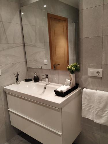 a bathroom with a white sink and a mirror at Casa da Xastra in Vimianzo