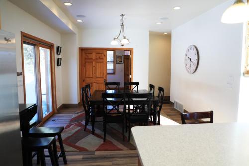 a dining room with a table and chairs and a clock at Zion Ponderosa Ranch Resort in Springdale
