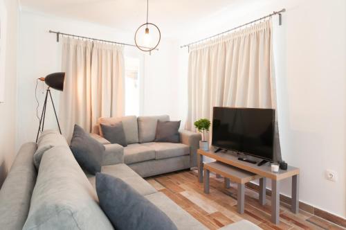 sala de estar con sofá y TV en Bill & Eva's precious jewel, en Pyrgadikia