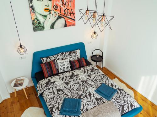 sypialnia z niebieskim łóżkiem i plakatem na ścianie w obiekcie La Cupola - Old City w Bukareszcie