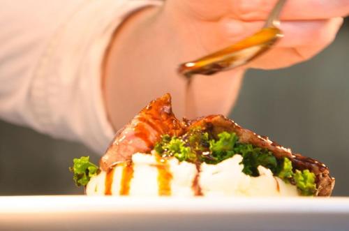 a person is eating a piece of food on a plate at The Wychwood Inn in Shipton under Wychwood