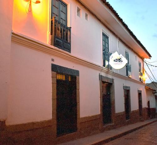 a white building with windows on a street at La Estación San Pedro in Cusco