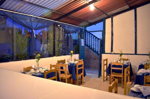 a dining room with tables and chairs and a balcony at La Estación San Pedro in Cusco