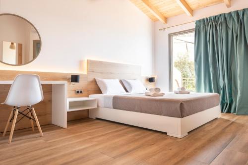 ein Schlafzimmer mit einem Bett, einem Spiegel und einem Stuhl in der Unterkunft First House in Himarë