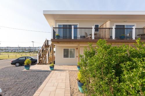 a house with a balcony and a parking lot at Aqualina Inn Montauk in Montauk