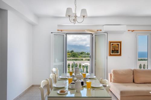 uma sala de jantar com uma mesa e um sofá em Pernari Apartments em Spartià