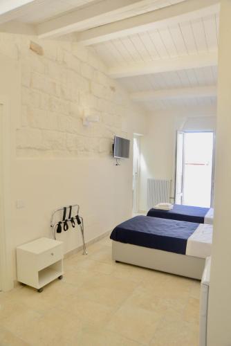 ein Schlafzimmer mit einem Bett und einem Fernseher an der Wand in der Unterkunft NMCpalace in Corato