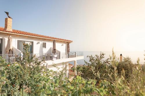ein weißes Haus mit dem Meer im Hintergrund in der Unterkunft First House in Himarë