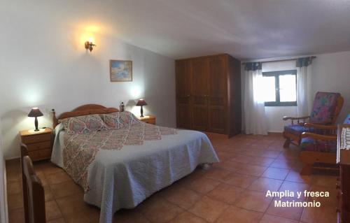 MalaにあるCasa "GARA" Mala-Lanzarote Norteのベッドルーム1室(ベッド1台、椅子付)