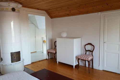 sala de estar con 2 sillas y chimenea en Villa Nyborg - By the Sea, en Estocolmo