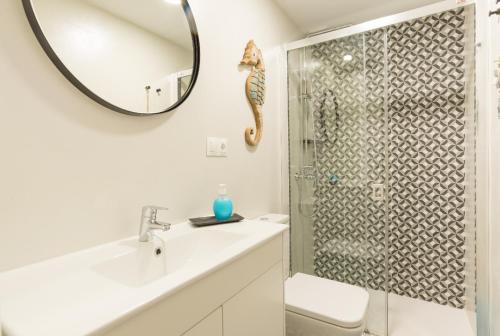 W łazience znajduje się prysznic, umywalka i lustro. w obiekcie Cozy Loft Near The Beach w mieście Torremolinos