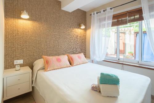 sypialnia z białym łóżkiem i oknem w obiekcie Cozy Loft Near The Beach w mieście Torremolinos