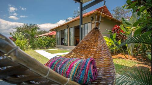 a hammock in front of a house at La Finca Lodge in Fortuna