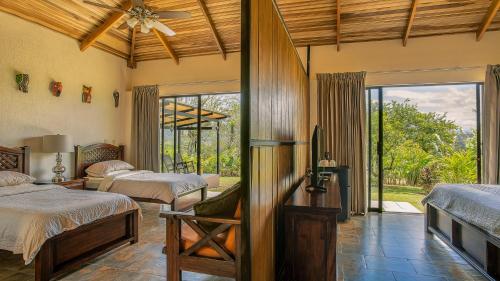 um quarto com 2 camas e uma ventoinha de tecto em La Finca Lodge em La Fortuna