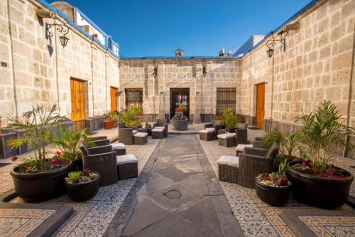 a courtyard with chairs and potted plants at Hotel Casona Solar in Arequipa