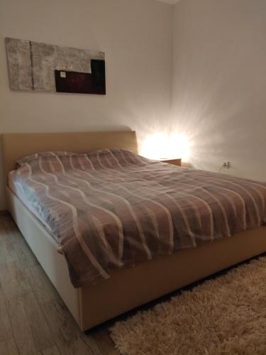 a bed in a bedroom with a lamp on a floor at Apartment Greta,50 METERS TO THE BEACH in Banjole