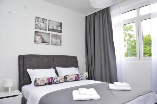 a bedroom with a bed with two towels on it at Small Oasis Apartment in Tivat