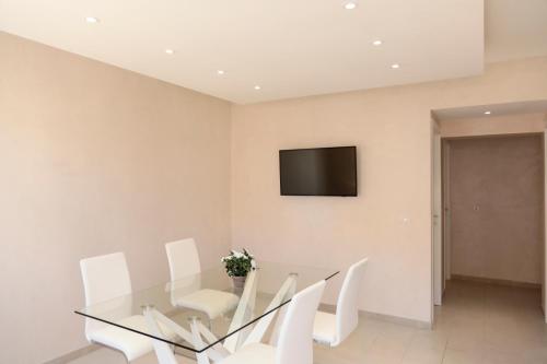 a dining room with a glass table and white chairs at R & D in Alghero