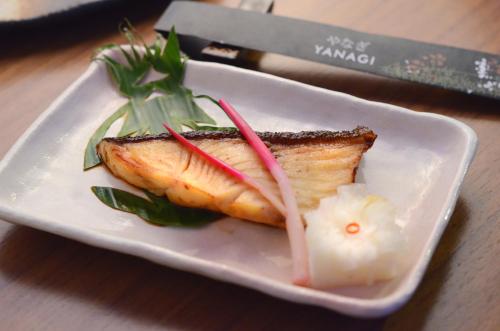 a white plate with a piece of fish on a table at Midas Hotel and Casino in Manila
