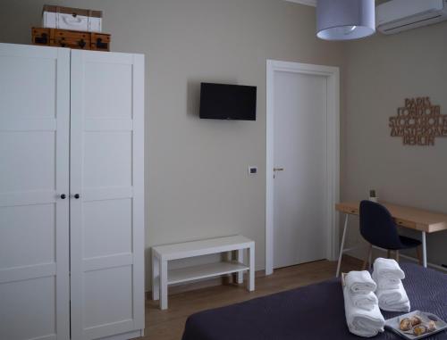 a bedroom with a bed and a desk and a tv at Viaggio in Sicilia B&B in Gravina di Catania