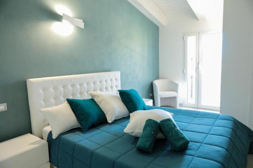 a blue and white bedroom with a bed with pillows at R & D in Alghero