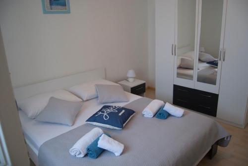 a bedroom with a bed with towels and a mirror at Vacation home Kairos in Sumartin