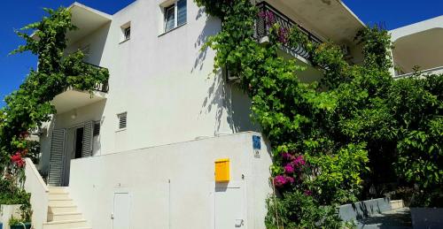 a white building with flowers on the side of it at Apartments Butkovic in Hvar
