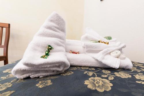 a pile of towels sitting on top of a bed at Hotel Il Melograno in Tempio Pausania