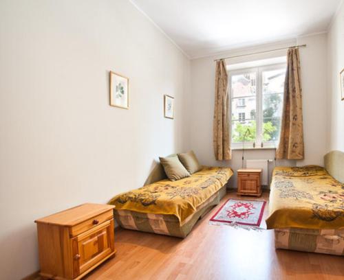 sala de estar con 2 camas y ventana en Apartament w Sercu Starówki, en Gdansk