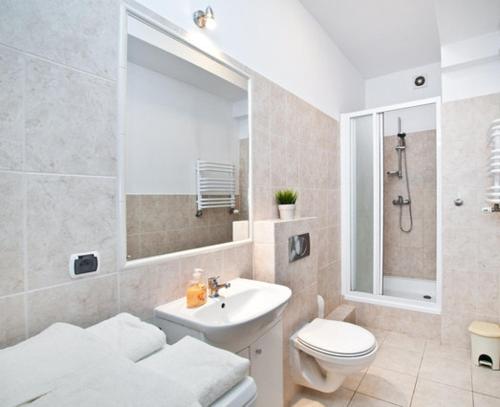 a white bathroom with a sink and a toilet at Apartament w Sercu Starówki in Gdańsk