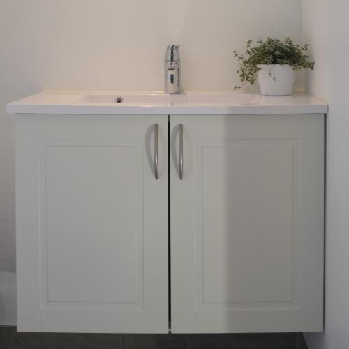 a white bathroom vanity with a sink at Brakkerhus in Egtved