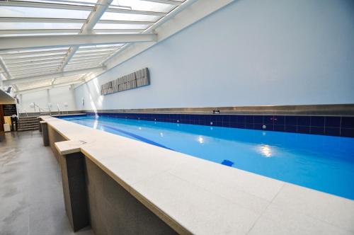 a large swimming pool in a building with a large pool at Private apartments in a Landmark Heritage Building in Auckland