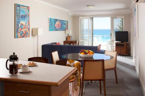 a living room with a blue couch and a table at Seashells Scarborough in Perth