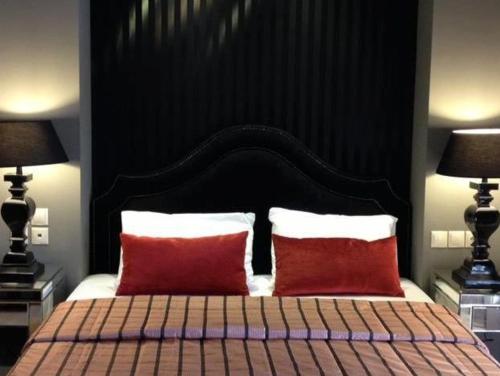 a bedroom with a large bed with two red pillows at Nerida Boutique Hotel in Dhimitsana
