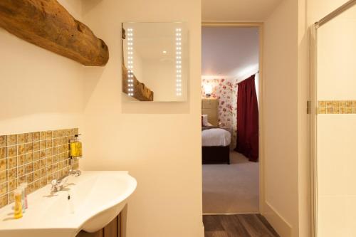 a bathroom with a sink and a mirror at The Wychwood Inn in Shipton under Wychwood
